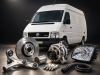 Запчасти для Volkswagen LT 96-06: как найти нужные детали и не переплатить Белый фургон Volkswagen в студии; на переднем плане — тормозной диск, генератор, фара и другие автозапчасти.